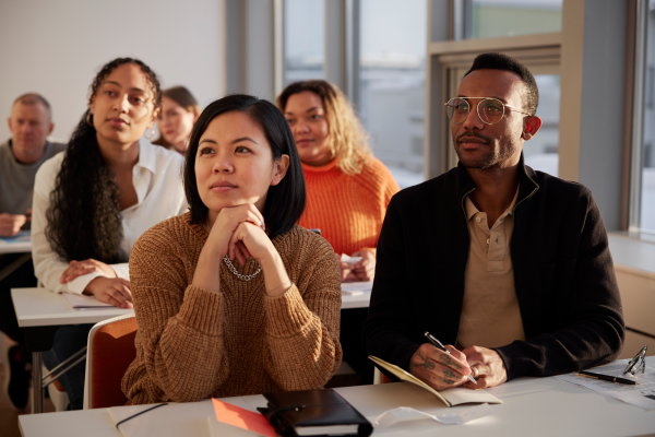 Folks attending a class and taking notes.